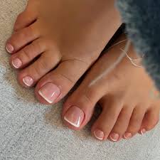 Gel pedicure with vibrant coral polish on neatly shaped toenails