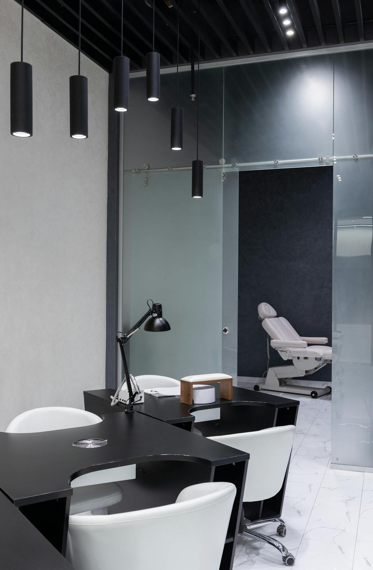 Nail technician carefully applying gel polish at a clean salon workstation with good lighting